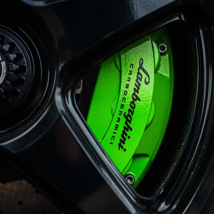 Lime green brake caliper behind a black wheel spoke