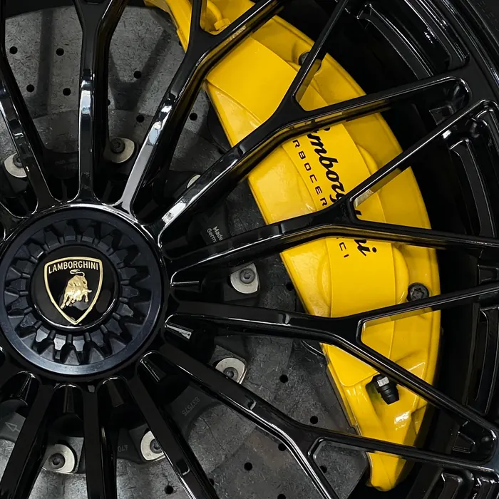 Yellow brake caliper behind a black multi-spoke wheel